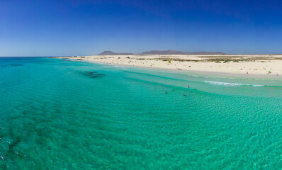 Fototapeta na wymiar Beautiful mid level aspect aerial panoramic view of Grandes Playa beach with clear turquoise water near Corralejo in Fuerteventura Spain