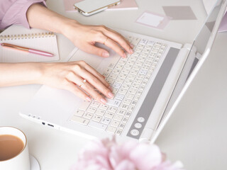 デスクでラップトップを使用する女性の手元、可愛い女性のワークスペース、オフィス、在宅勤務のコンセプト