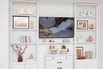 TV and shelves with different decor in room. Interior design