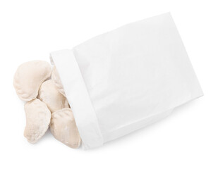 Paper bag of raw dumplings (varenyky) with tasty filling on white background, top view