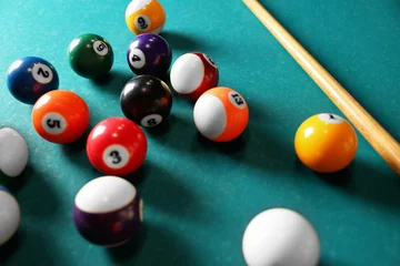Foto op Plexiglas Many colorful billiard balls and cue on green table, closeup © New Africa