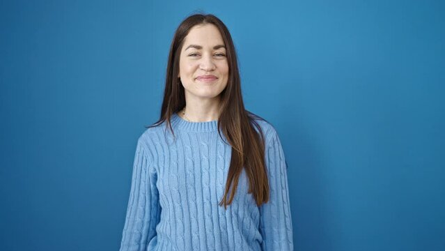 Young caucasian woman smiling confident saying yes with head over isolated blue background