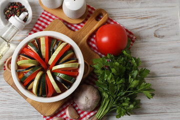Cooking delicious ratatouille. Dish with different vegetables on white wooden table, flat lay