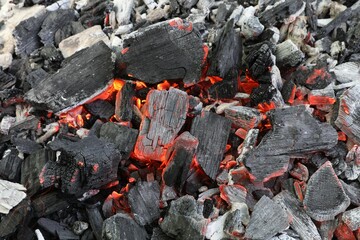 Many smoldering coals as background, closeup view