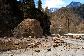 A huge rock fell from the mountains onto the road, destroying the asphalt and blocking half of the...