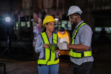 Engineer and manager look at tablet checking the maintenance part while the welder welding sparking
