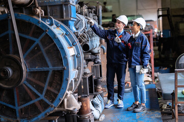 Plakat Two technical workers working in a maintenance shop checking heavy engine industry factory 