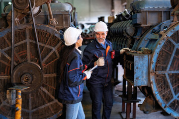 Fototapeta na wymiar Two technical workers working in a maintenance shop checking heavy engine industry factory 