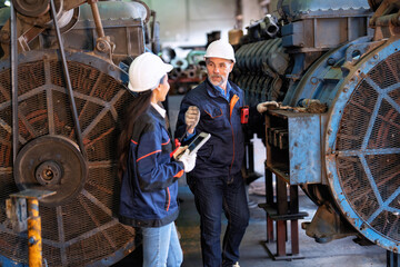 Fototapeta na wymiar Two technical workers working in a maintenance shop checking heavy engine industry factory 