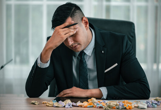 After having difficulties with the project's actual implementation, the CEO feels stress and concern, causing him to angrily crumple some sticky notes, which contained a number of different ideas.