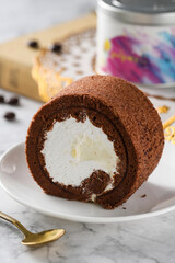 Chocolate swiss cake roll, on a tabletop on a white background, indoors, close-up