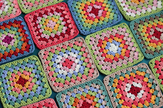 Crochet project in making. Colorful crochet squares close up photo. Hand made top in process. 