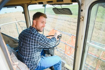 Farmer driving combine and harvesting crop.