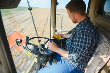 Farmer driving combine and harvesting crop.
