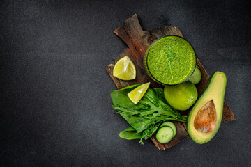 green fresh smoothie on dark background. Detox, dieting, clean eating on a dark background. place...