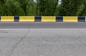 black and yellow concrete fenders along the road