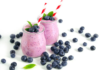 Two glasses of blueberry smoothie on white background. Selective focus
