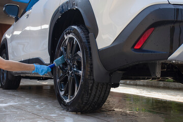 Fototapeta na wymiar Car wash, hand cleaning car wheel