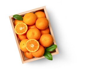 Orange fruit with half slice and green leaf in wooden crate isolated on white background, top view, flat lay.