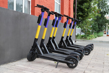 Electric scooters for public share standing outside on the city street. Public mobile...