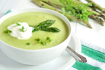 Asparagus cream soup on white wooden background
