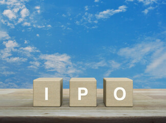 IPO letter on wood block cubes on wooden table over blue sky with white clouds, Initial public...