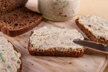 Slices of spreaded rye bread on wooden background