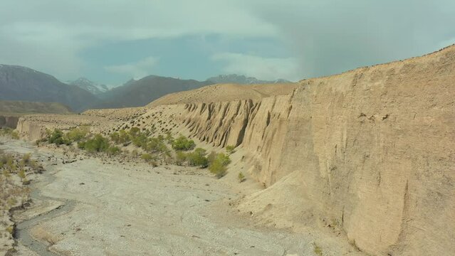 Bird's eye view from drone along scenic sandy canyon. Kyrgyzstan, Central Asia. Epic scenery and breathtaking views of highland.