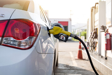 Transportation and ownership concept - man pumping gasoline fuel in car at gas station. hight price...