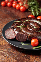 Black pudding or blood sausage with rosemary and tomatoes.