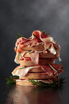 Italian prosciutto or Spanish jamon with bread and rosemary.