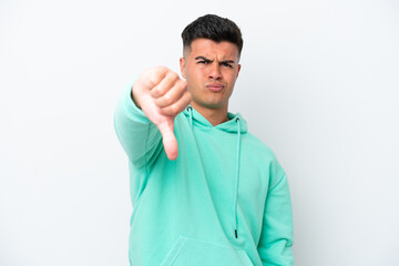 Young caucasian handsome man isolated on white background showing thumb down with negative...