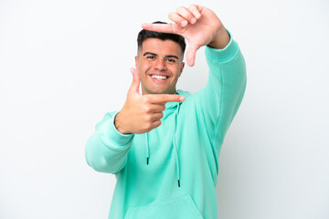 Young caucasian handsome man isolated on white background focusing face. Framing symbol