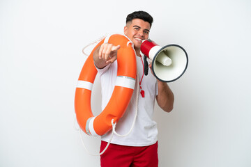 Young handsome man isolated on white background with lifeguard equipment and shouting through a megaphone - obrazy, fototapety, plakaty