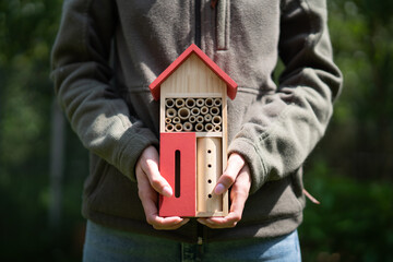 Spring home garden. A bee house held by a person/