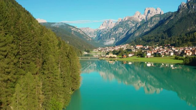 Scenic Santa Caterina and Auronzo lakes with azure water against Tre Cime di Lavaredo mountain. Small town and forestry hills on sunny day aerial view