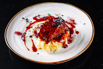 Stewed veal cheeks with mashed potatoes on plate
