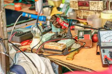 The cluttered workbench of an electronics repairman. - 607001302