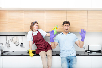 Obraz premium Positive young couple amusing while cleaning home together. Funny household concept 