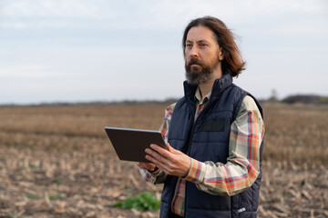 Farmer with digital tablet on an agricultural field. Smart farming and digital agriculture	