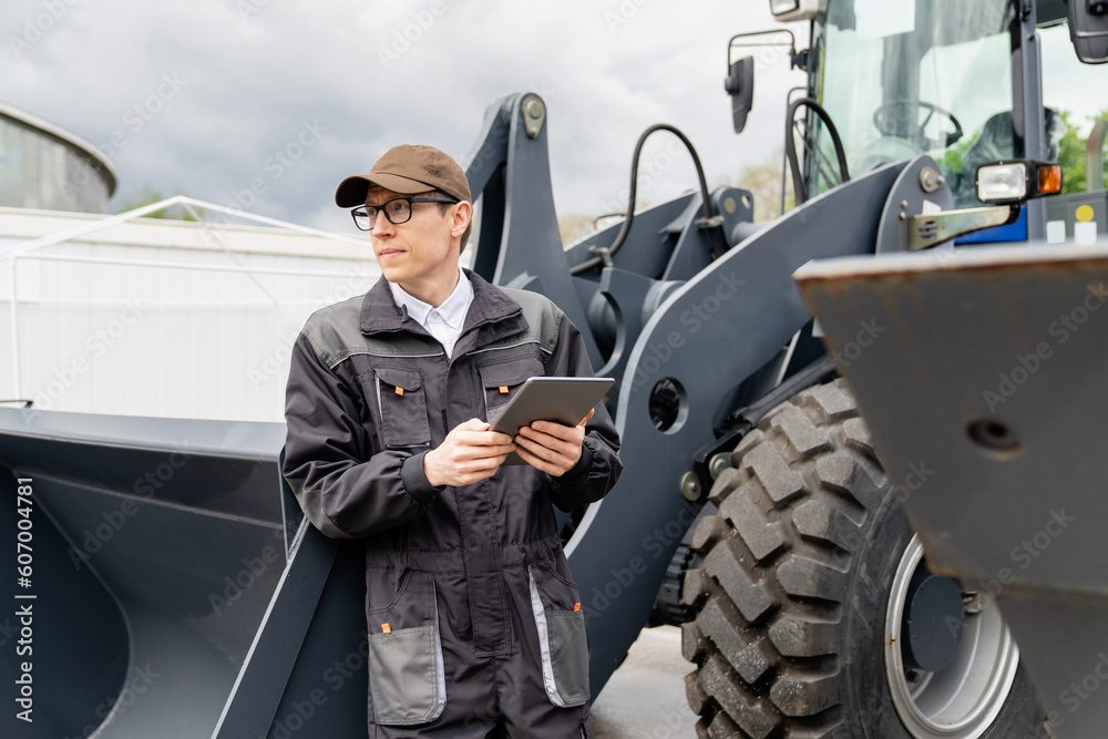 Aufkleber serviceman with digital tablet on a background of the tractor
