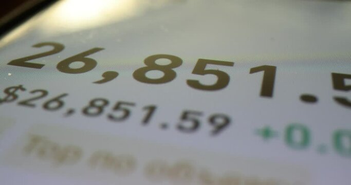 Tracking rise and fall of money exchange rate quotes on online wallet on digital device. Concept of profit and finance on trading. Earnings on internet