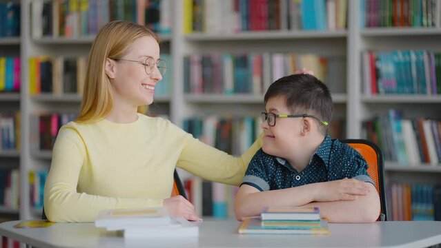 Female teacher educational psychologist and Down syndrome boy share positive emotions in education