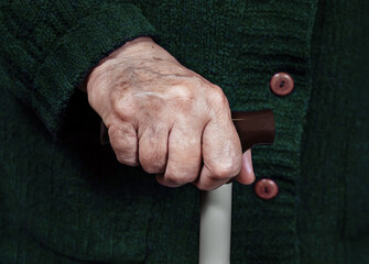 Hand of an elderly woman on a cane