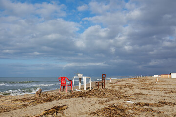 Two Chairs and a Plastic Side Table with a Colander Resting on top with Wood Remains