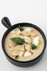 cream of mushroom soup in bowl on white background