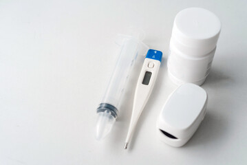 Fingertip Pulse Oximeter and a bottle of medicine and a syringe, Medical Monitor and Home Health Care Concept.