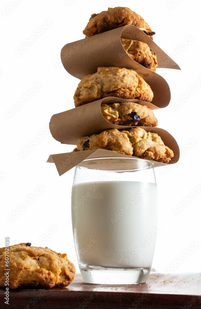 Wall mural Vertical sot of a bunch of cookies put on a glass full of milk on the table on the white background