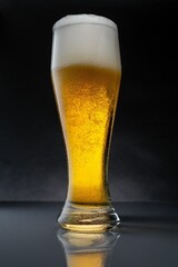 Vertical shot of a glass of beer on a grey background