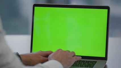 Fototapeta na wymiar Hands writing green screen laptop in office closeup. Businessman typing document